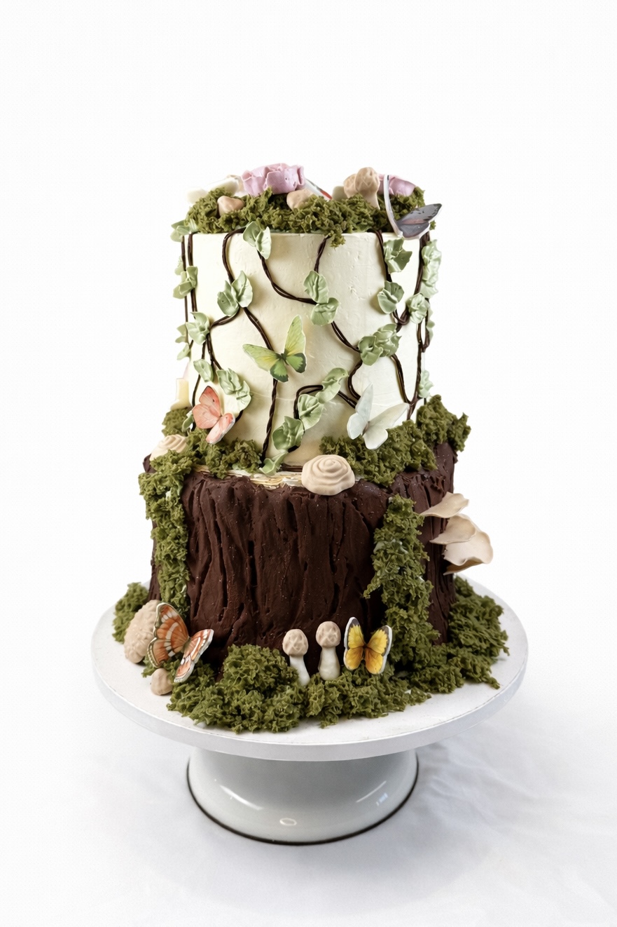 Enchanted forest two-tier cake with chocolate bark, moss, vines, and butterflies