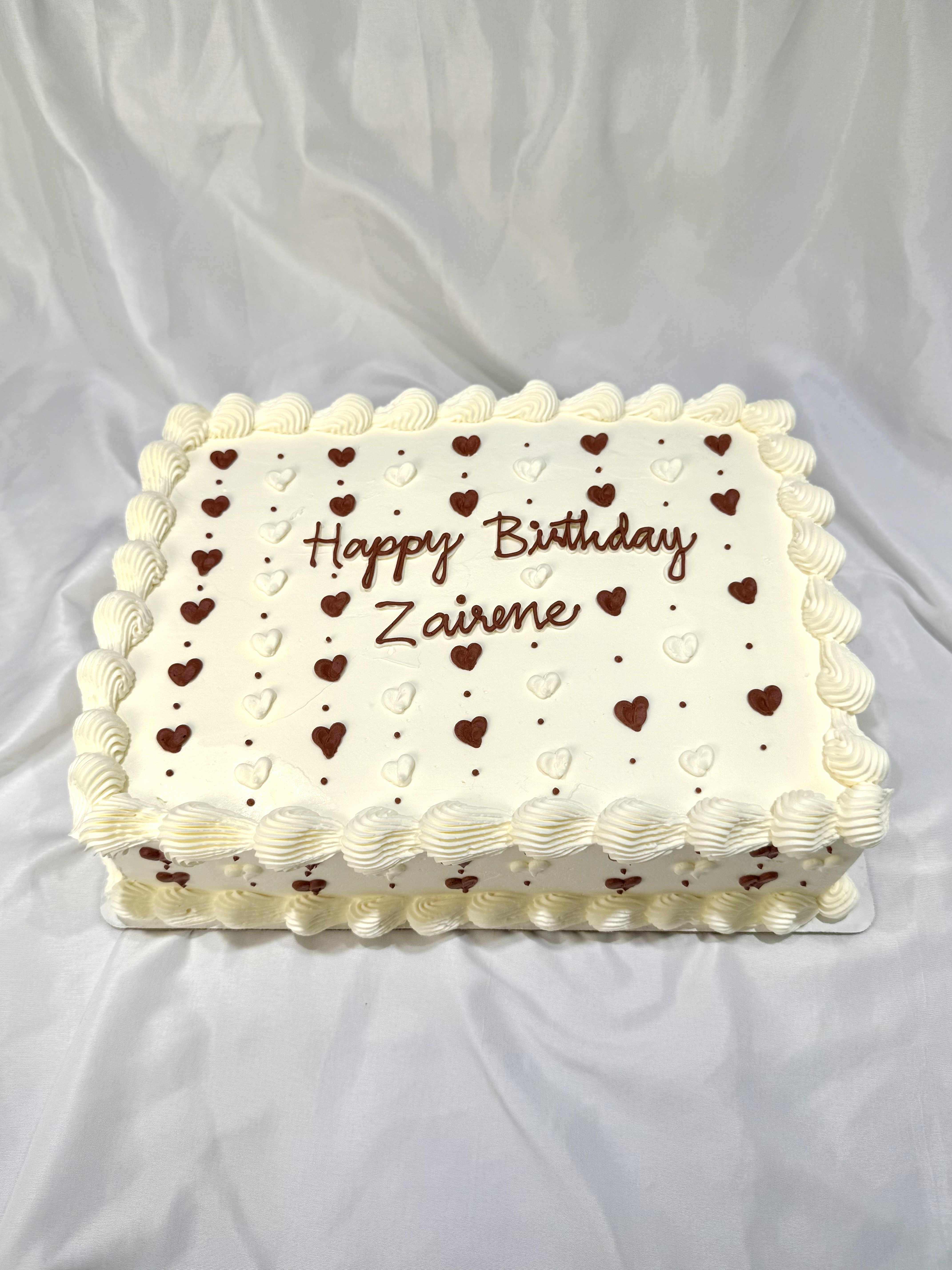 Happy Birthday sheet cake with piped chocolate and white hearts