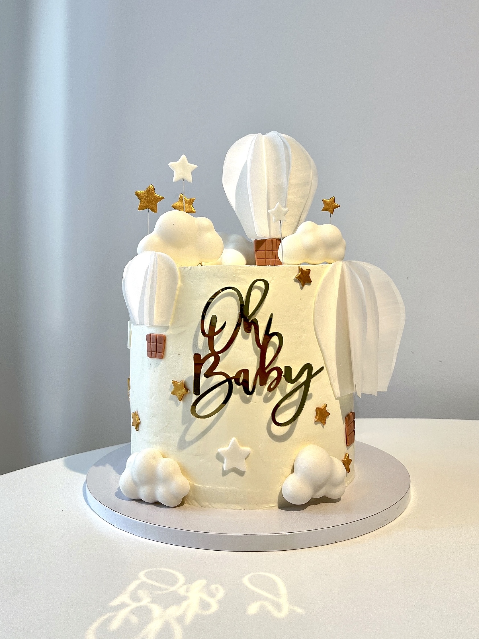 Oh Baby shower cake with fondant hot air balloons, clouds, and gold stars