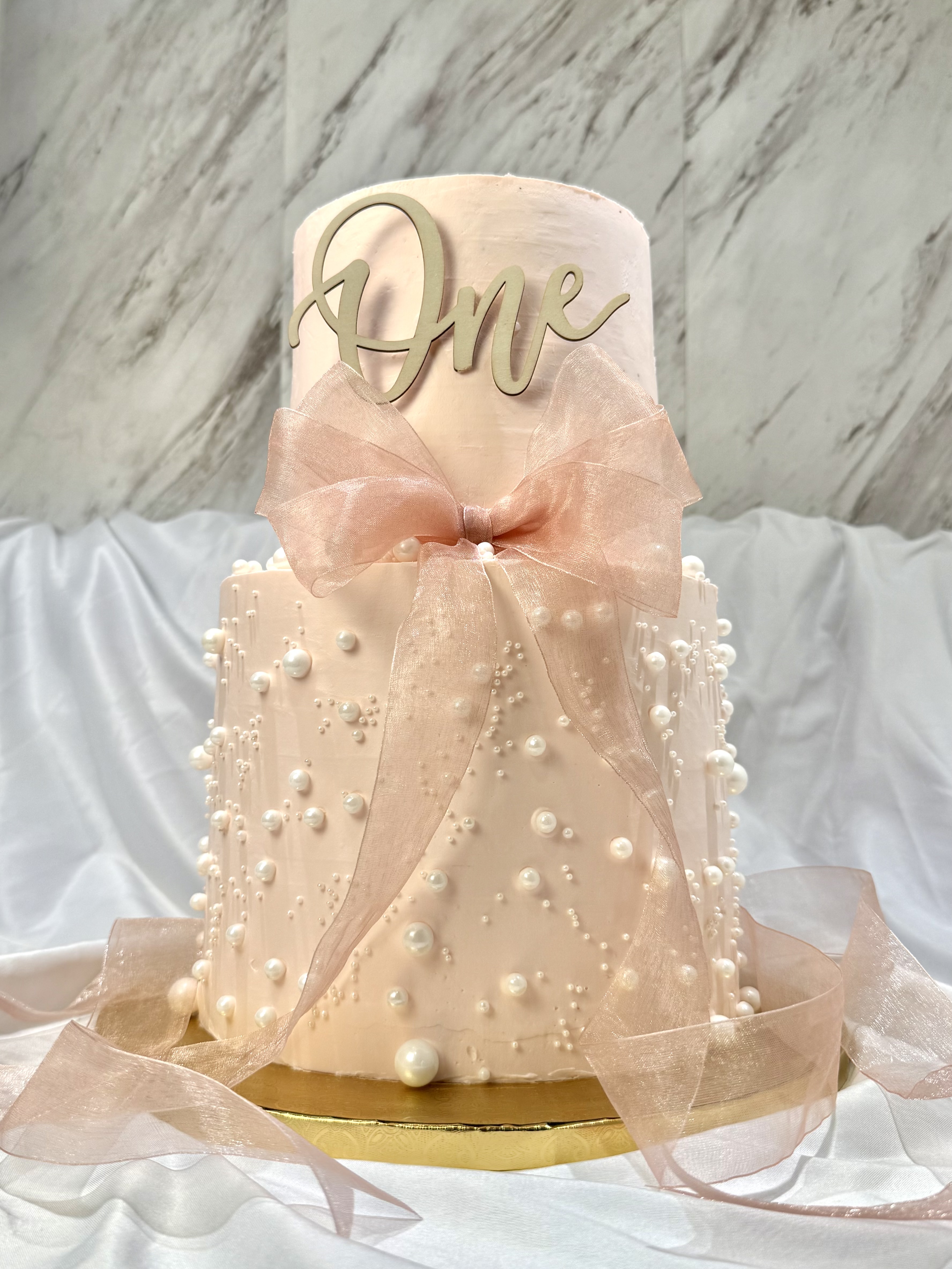 Blush two-tier pearl cake with organza bow