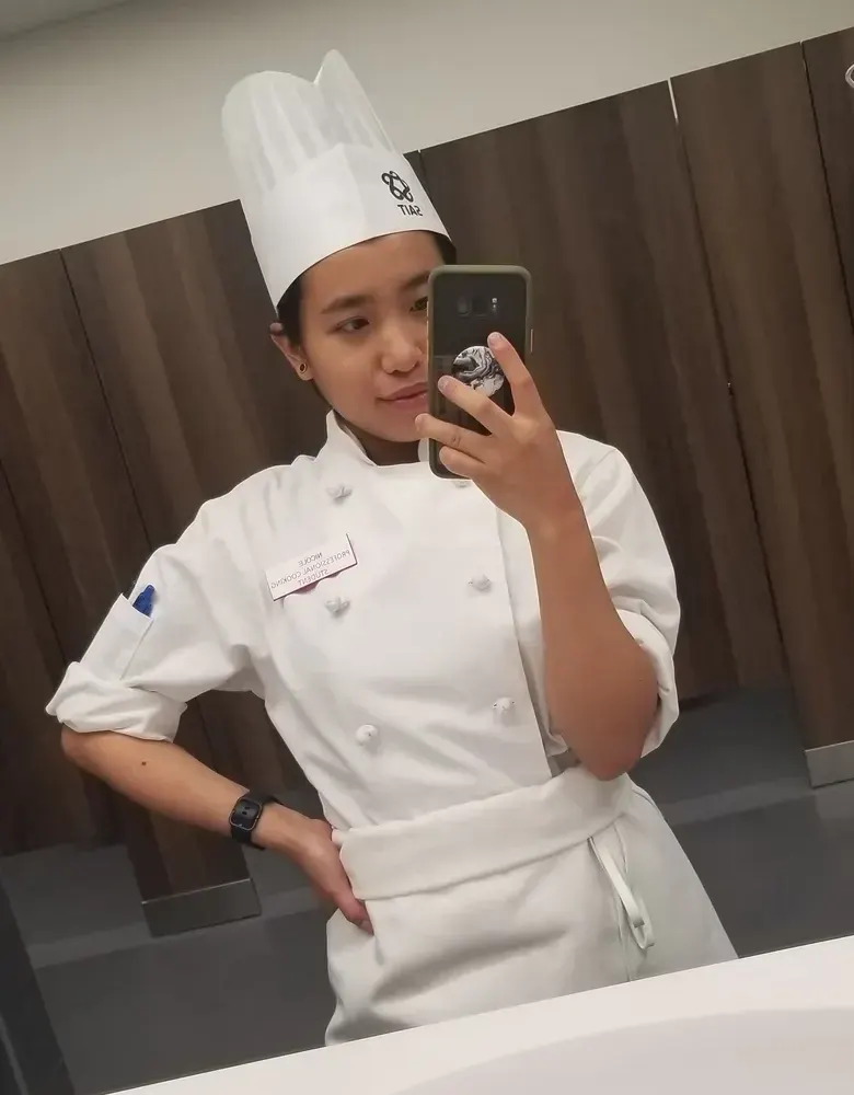 Nicole’s mirror selfie in her SAIT chef hat and jacket